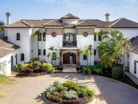 Stunning facade of an authentic Andalusian villa with breathtaking sea views, showcasing traditional architectural elements such as terracotta tiles, ornate detailing, and arched windows, blending timeless Andalusian charm with panoramic views of the ocean.