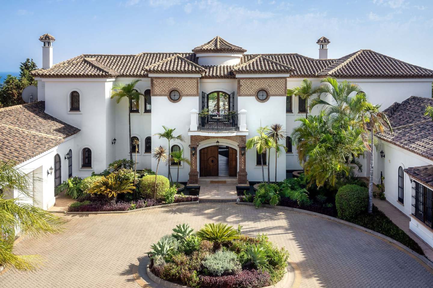 Stunning facade of an authentic Andalusian villa with breathtaking sea views, showcasing traditional architectural elements such as terracotta tiles, ornate detailing, and arched windows, blending timeless Andalusian charm with panoramic views of the ocean.