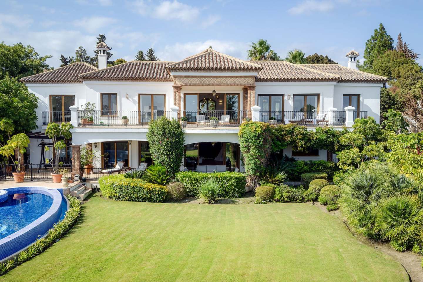 Lush lawn in an authentic Andalusian villa with breathtaking sea views, featuring well-maintained greenery, elegant outdoor spaces, and a serene atmosphere that seamlessly blends with the surrounding natural beauty and panoramic ocean vistas.