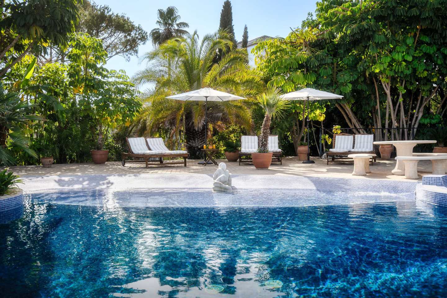 Stunning pool area at an authentic Andalusian villa, featuring a beautiful infinity pool that seamlessly blends with the breathtaking sea views. The space combines traditional Andalusian charm with modern luxury, offering a perfect setting for relaxation and outdoor entertainment, surrounded by lush gardens and the tranquil beauty of the coastline.