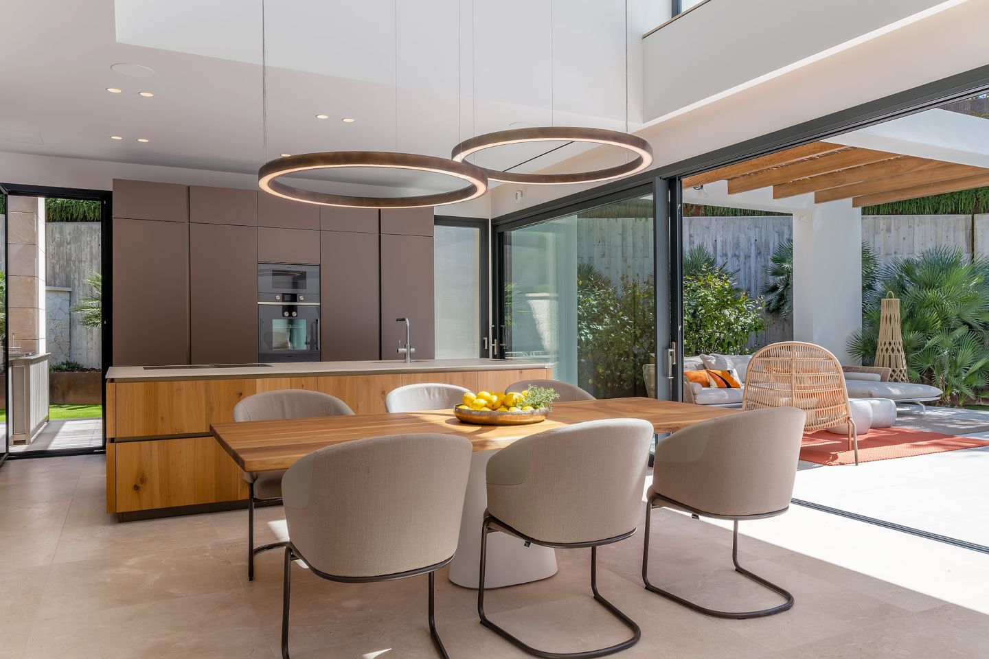 Stylish dining room in a contemporary beachside villa in Bendinat, Mallorca, featuring a sleek modern table, elegant lighting, and seamless access to a spacious terrace with breathtaking sea views for an unparalleled dining experience.