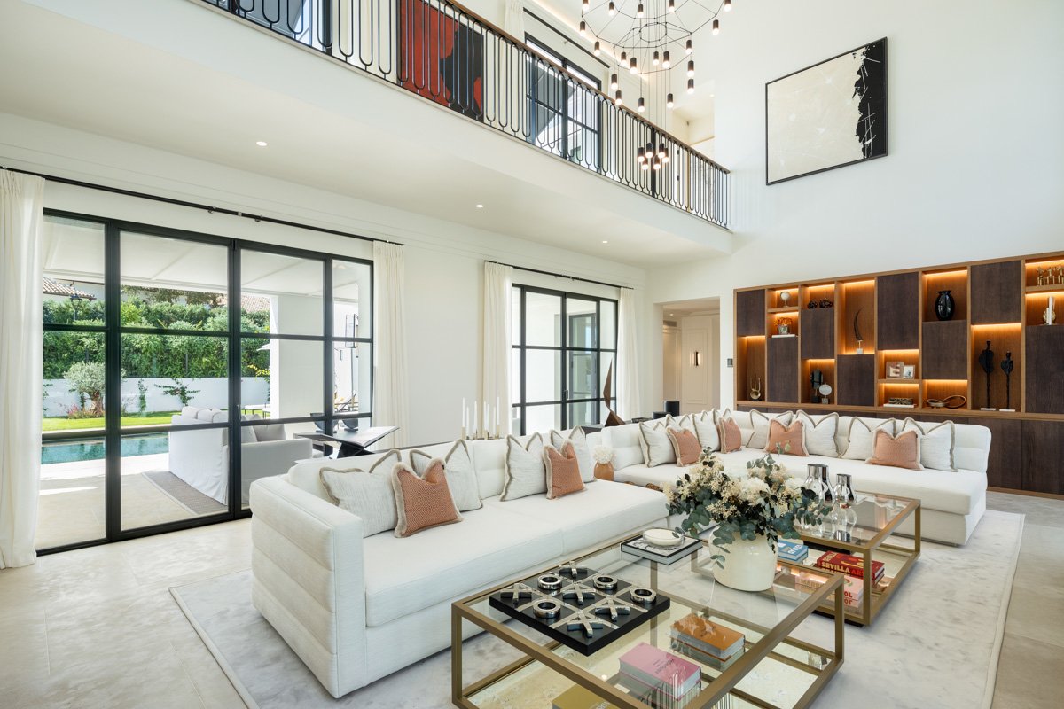 Sophisticated living room in an elegant villa in Cascada de Camoján, Marbella’s Golden Mile, featuring luxurious furnishings, tasteful decor, and an open layout that flows seamlessly into the rest of the home. Large windows offer breathtaking views of the lush surroundings, creating a serene and welcoming atmosphere.