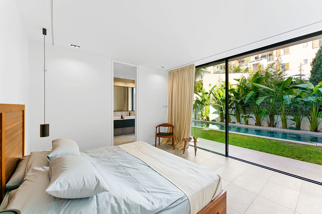 Elegant bedroom in an elevated sea view villa in Palma de Mallorca, featuring luxurious decor and stunning views of the pool and ocean.