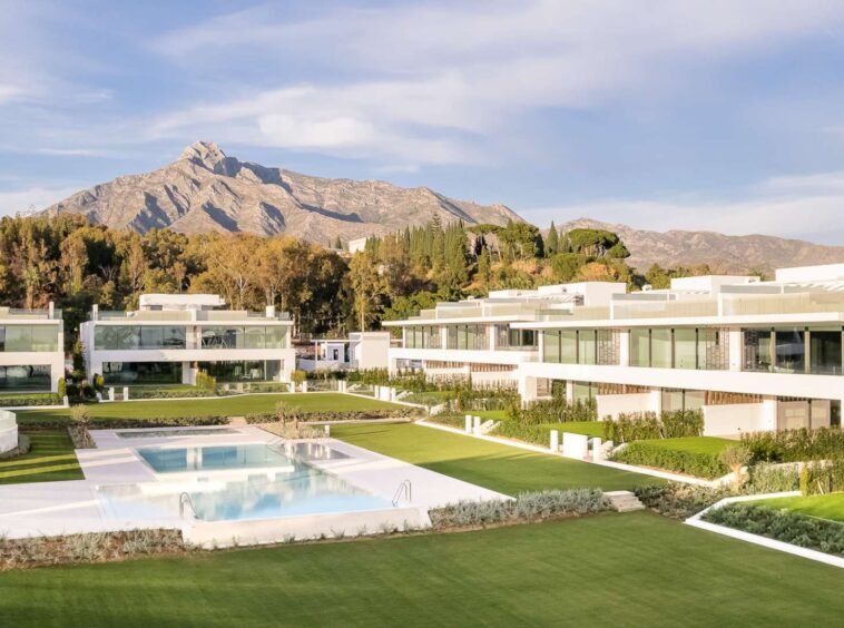 Stunning luxury residence near Puente Romano on the Golden Mile, featuring a sophisticated modern facade with clean architectural lines, warm ambient lighting, and lush tropical landscaping. The villa’s elegant design seamlessly blends contemporary style with timeless elegance, creating an inviting and exclusive atmosphere.