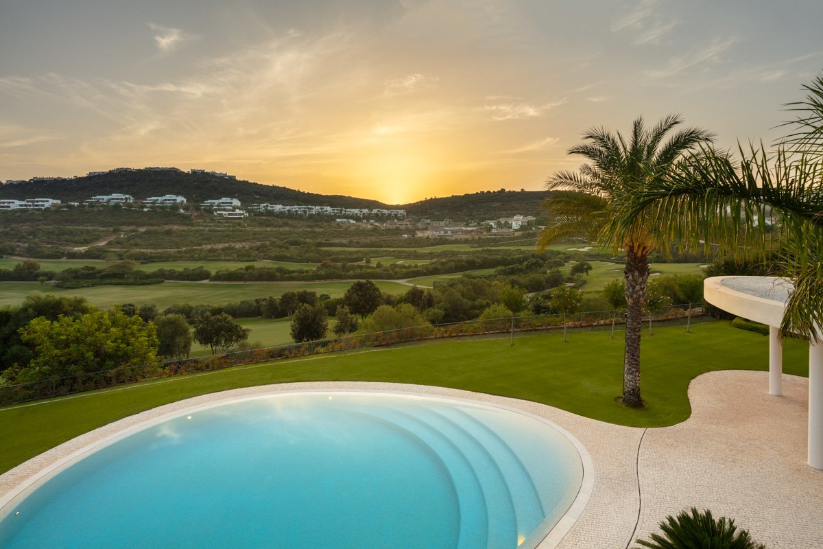 Stunning golf course views from a futuristic villa in Finca Cortesín, Marbella, designed by Vicens Ramos, showcasing expansive windows that frame the lush greenery and rolling fairways, creating a serene and luxurious atmosphere that blends modern architecture with nature.