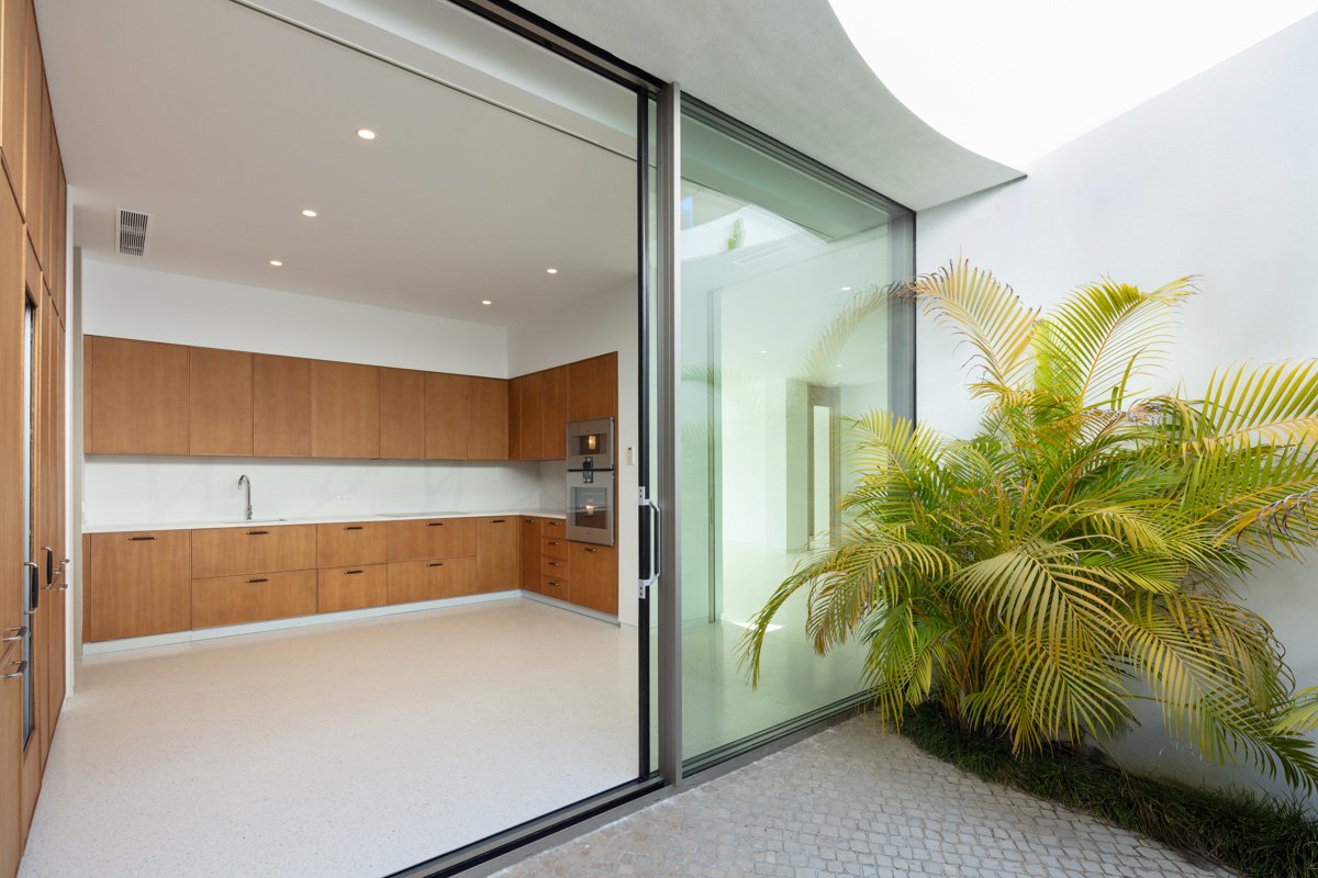 Sleek, modern kitchen in a futuristic villa in Finca Cortesín, Marbella, designed by Vicens Ramos, featuring cutting-edge appliances, minimalist cabinetry, and clean lines that blend seamlessly with the villa’s innovative architectural style, creating a high-end, functional space for culinary excellence.