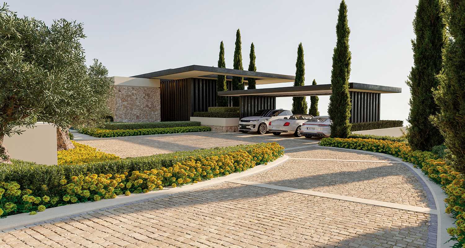 A scenic view of the driveway leading to a prime plot in La Zagaleta, Marbella, showcasing a well-maintained path framed by lush greenery and mature trees. The surrounding landscape hints at the luxurious, exclusive nature of the property, with ample space for future development in a tranquil, upscale setting.