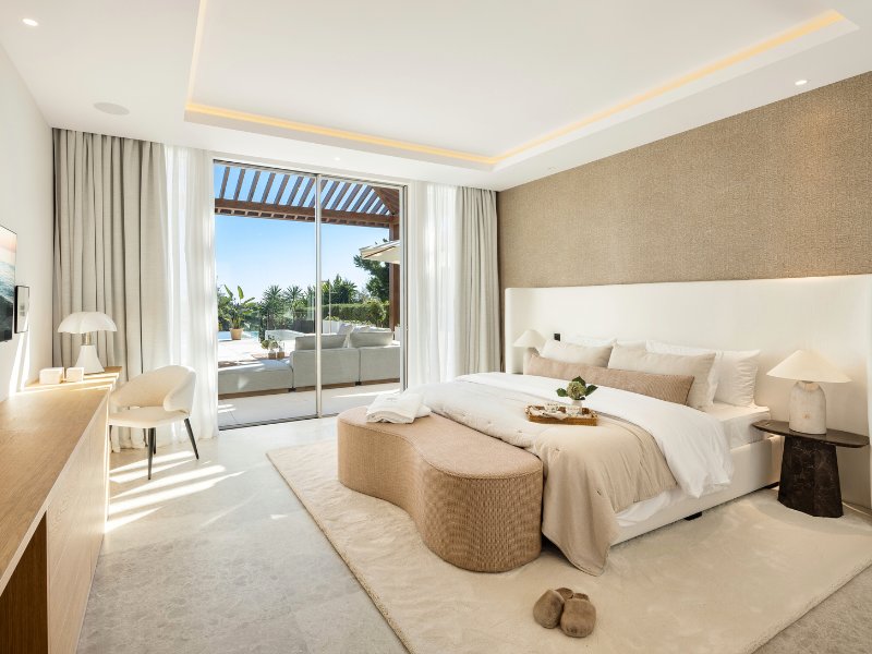 Luxurious bedroom in a villa with stunning golf and mountain views, featuring modern furnishings, large windows that frame the picturesque landscape, and a serene, spacious design that creates a peaceful retreat for relaxation and comfort.