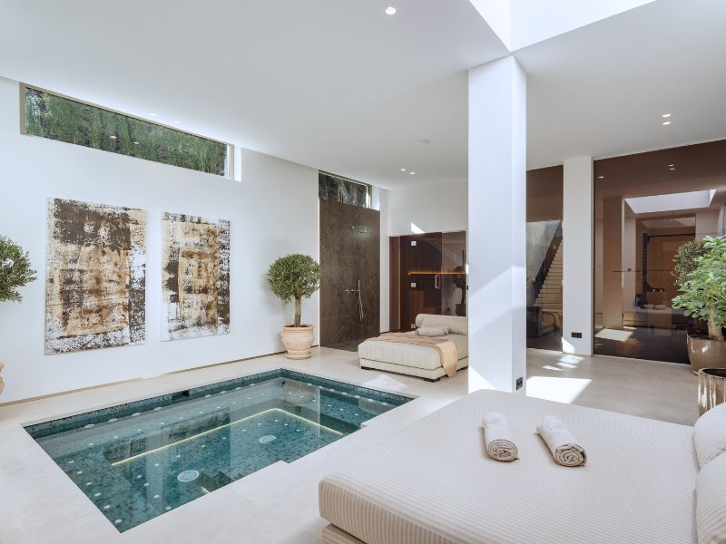 Exquisite indoor pool in a luxury villa with stunning golf and mountain views, featuring a spacious design with ambient lighting, sleek modern finishes, and large windows that provide a seamless connection to the surrounding natural beauty, offering a serene and private retreat.