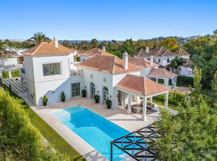 Elegant facade of a refined villa in Nueva Andalucía, where luxury meets Provençal charm. The villa features traditional architectural details combined with modern design elements, offering a harmonious blend of rustic and contemporary aesthetics. Surrounded by lush greenery, the exterior exudes warmth and sophistication, creating a welcoming atmosphere in a serene, upscale setting.