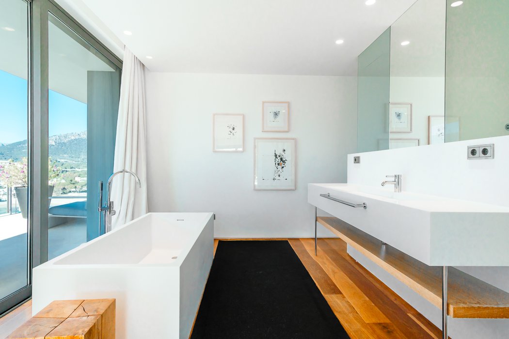 Luxurious bathroom in a seafront villa in Camp de Mar, Mallorca, featuring a freestanding bathtub with stunning sea views, modern fixtures, and elegant marble finishes. The design combines contemporary style with natural light, creating a serene and opulent space perfect for relaxation with the soothing sound of the ocean in the background.