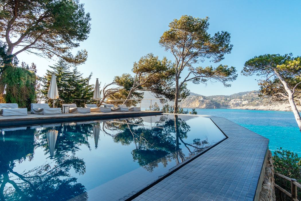 Stunning infinity pool at a seafront luxury villa in Camp de Mar, Mallorca, seamlessly blending with the Mediterranean Sea. The pool offers expansive views of the coastline, creating a serene and luxurious space for relaxation, with sleek modern design elements enhancing the villa's elegance.