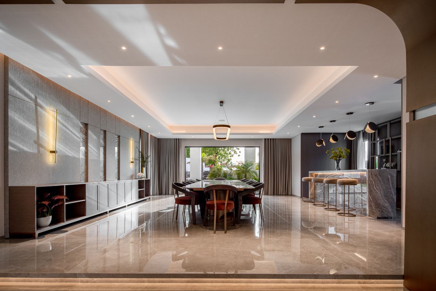 Sophisticated dining room in an ultra-luxury mansion in Emirates Hills, featuring a large, elegant dining table, plush seating, and modern chandelier lighting. Floor-to-ceiling windows offer stunning skyline views, enhancing the luxurious ambiance.